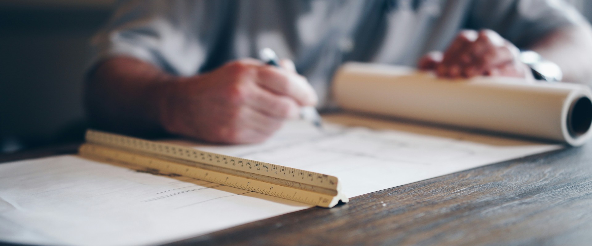 Tight photo of man writing on a blueprint