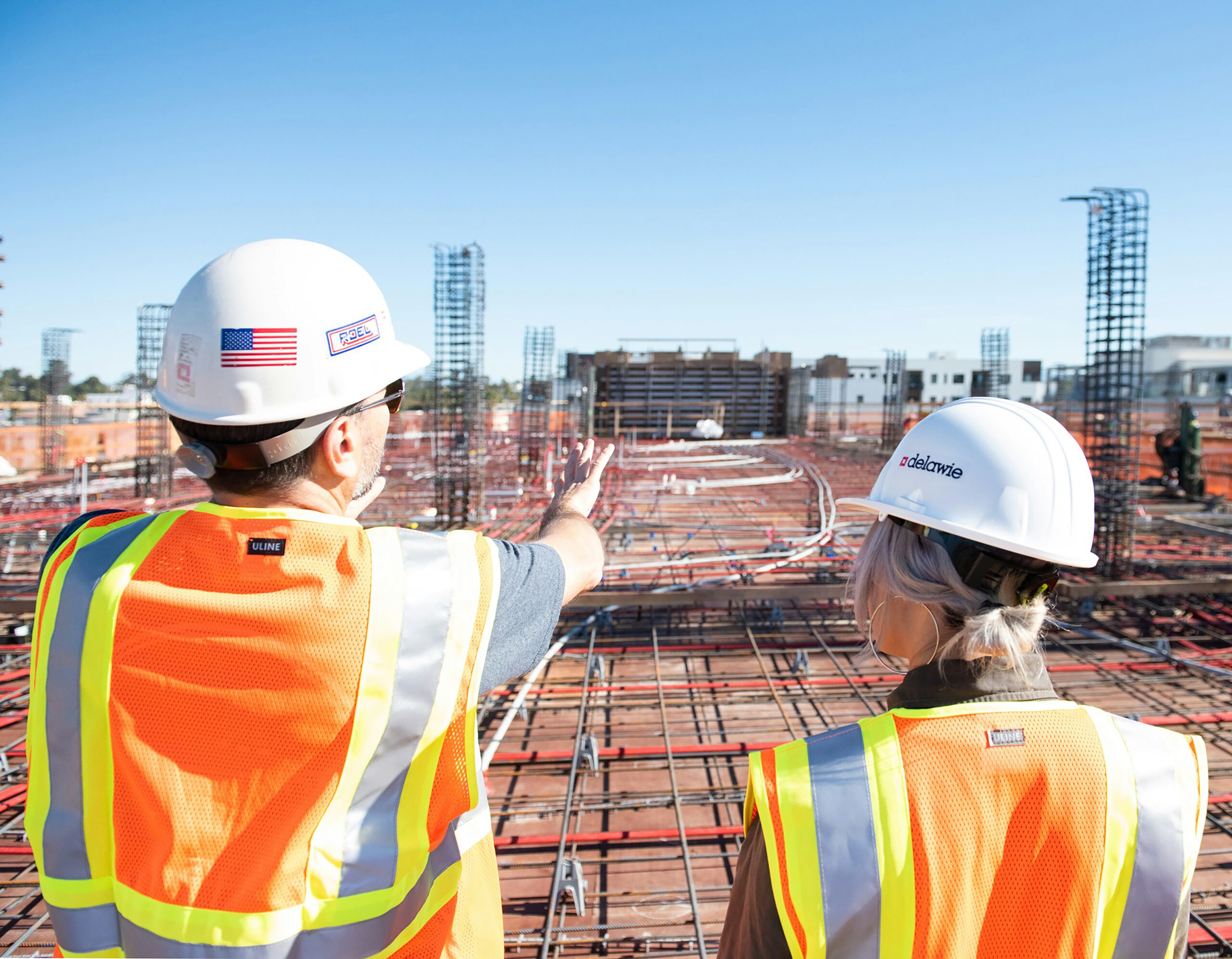 Two construction project managers pictured overseeing a construction project.