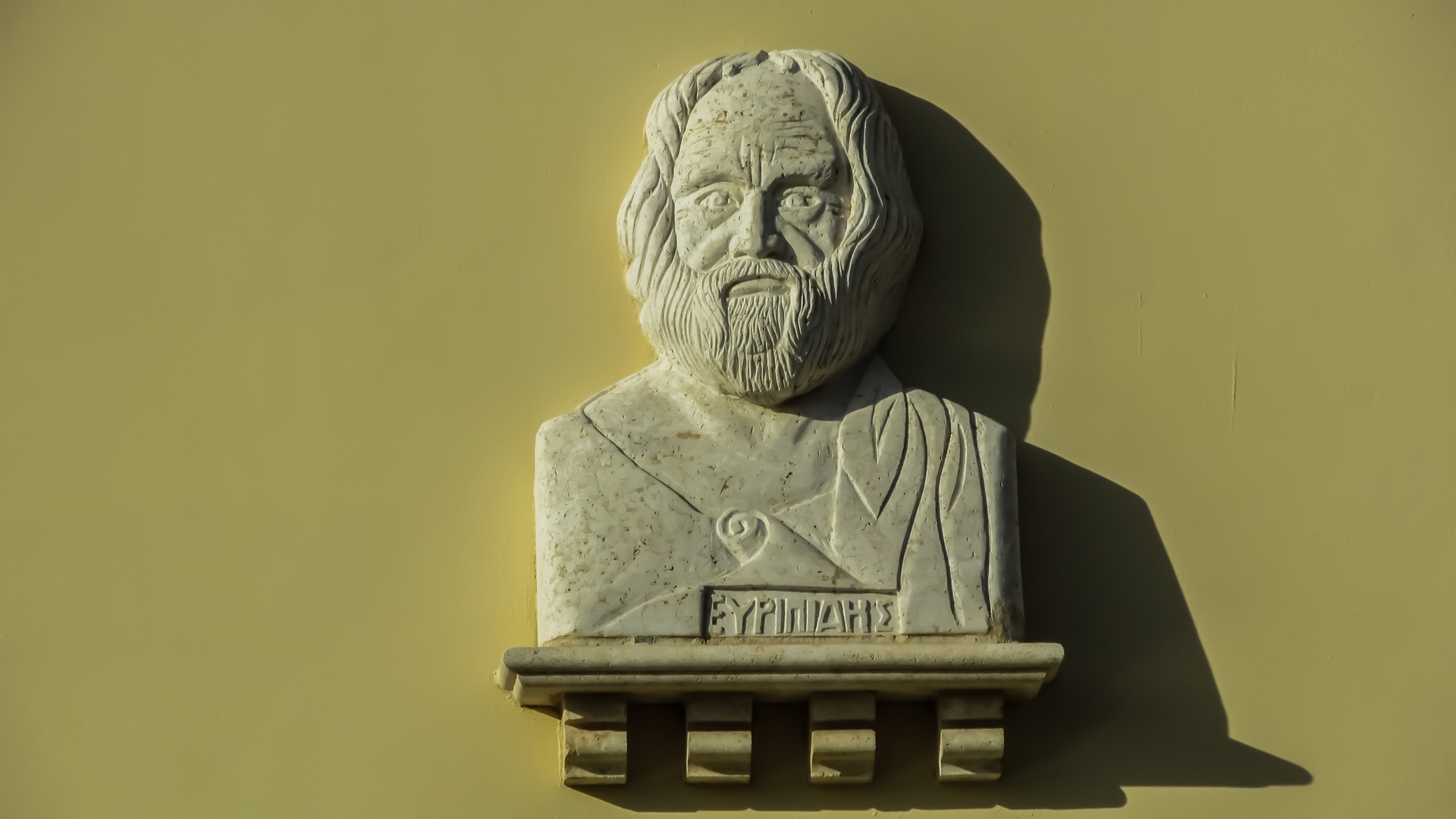 Sculpted bust of Kippocrates against olive background